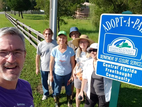 Central Florida Freethought Community poses in front of their adopt-a-park sign